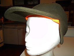 Warme Winterkappe mit Schild und Ohrenschutz in Olivgrün und innen orange. Rückseitig Klettverschluß